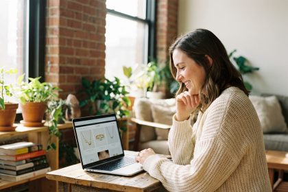 Jeune femme souriante utilisant un ordinateur portable dans un intérieur cosy